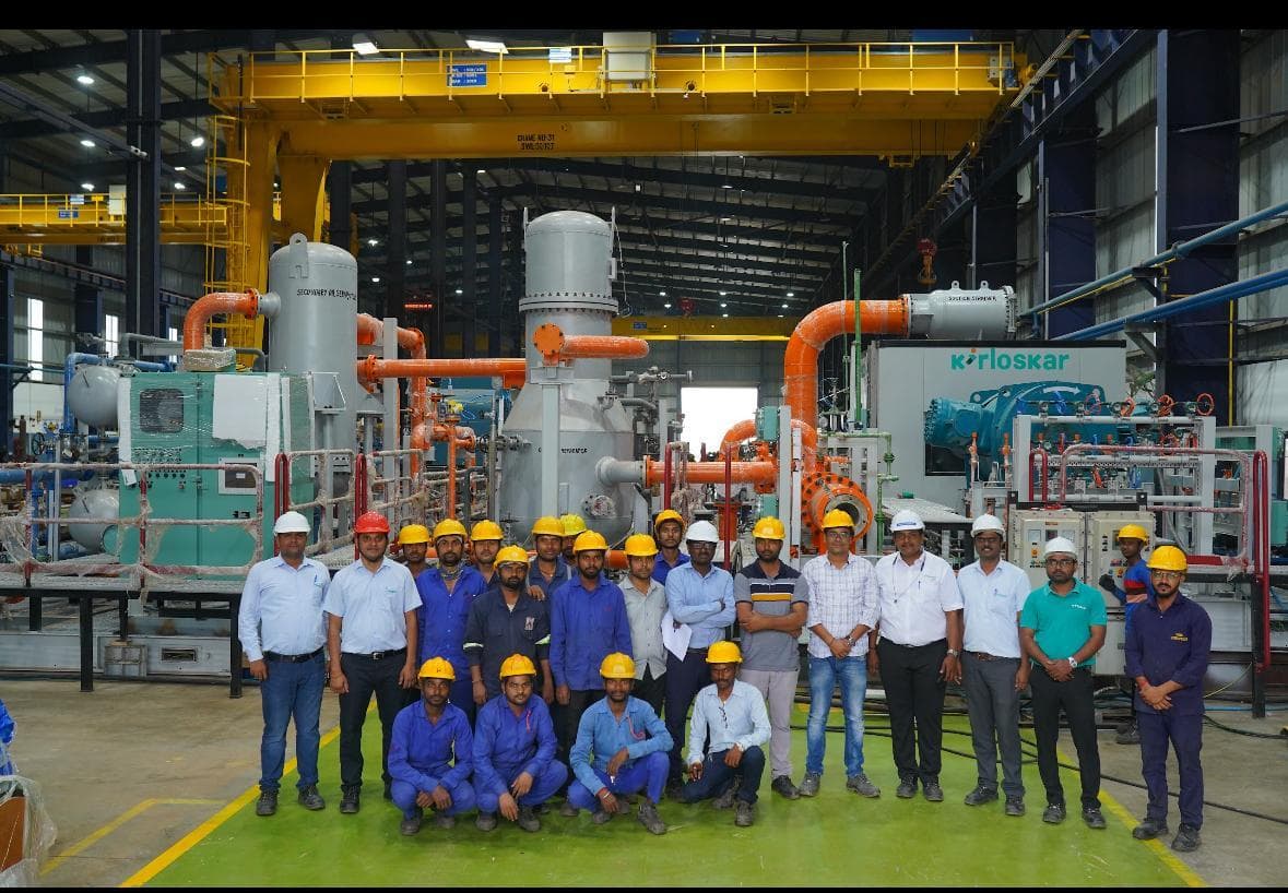 The REC workforce together in front of a compressor package