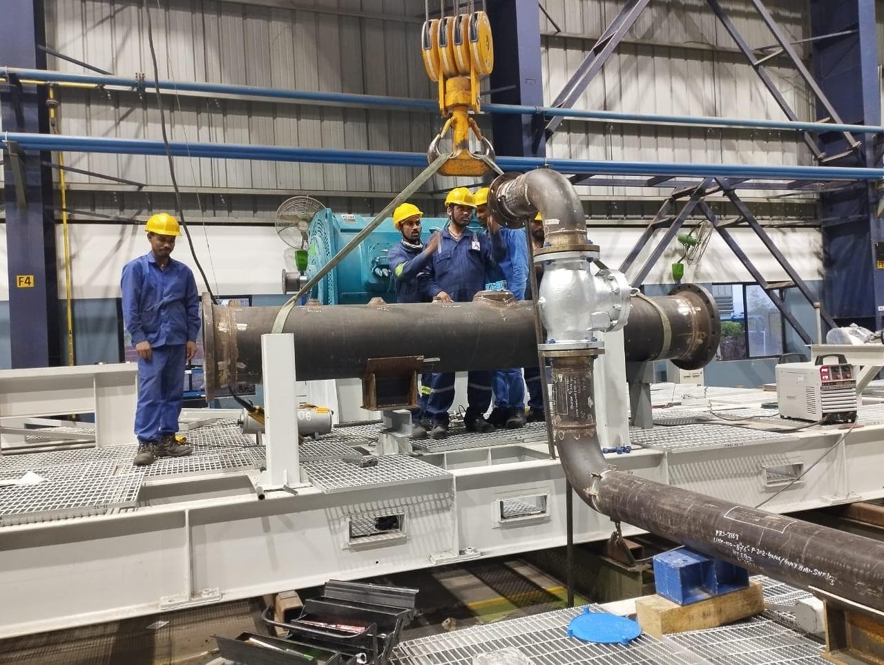 REC workers fitting piping and equipment on site