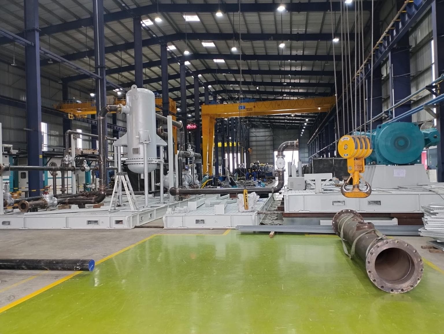 Industrial fabrication workshop with piping and equipment skids